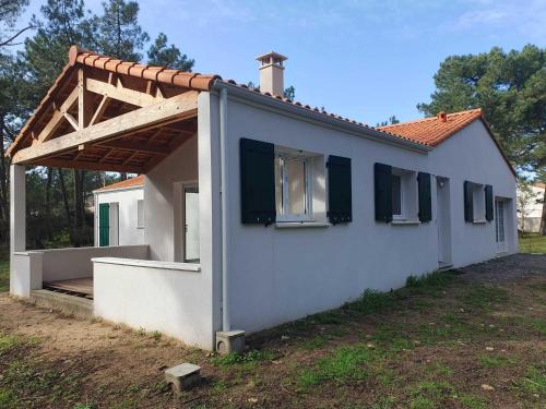 une petite maison blanche avec un toit en bois dans l'établissement Maison bord de mer - la Tranche sur mer, à La Tranche-sur-Mer