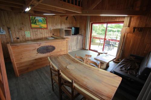 a kitchen and dining room in a log cabin at Cerza Safari Lodge in Hermival-les-Vaux