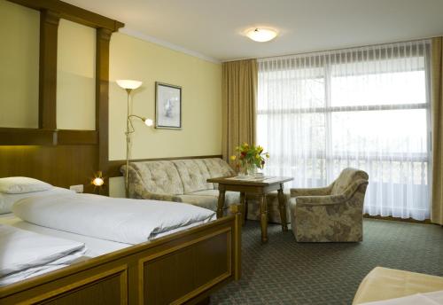 um quarto de hotel com uma cama e um sofá em Bad Füssing Appartementhof Aichmühle em Bad Füssing