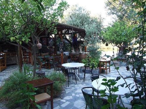 eine Außenterrasse mit Tischen, Stühlen und Bäumen in der Unterkunft The Hotel Cafe Bistro in Ortaca
