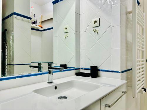 une salle de bain blanche avec un lavabo et un miroir dans l'établissement Superbe appartement vue mer dans résidence avec piscine, à Théoule-sur-Mer