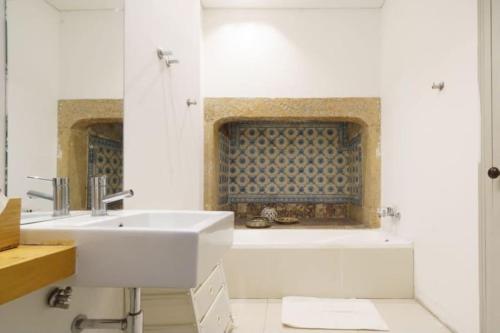 a bathroom with a sink and a bath tub at Pink Street Apartment in Lisbon