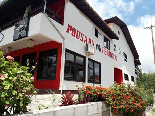 um edifício com uma fachada vermelha e branca em Pousada Via Ferrugem em Garopaba