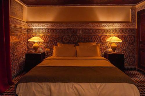 a bedroom with a large bed with two lamps at LUXURY apartment in Marrakesh