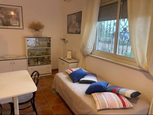 a bedroom with a bed with pillows and a window at Villetta Greco - Torre Lapillo in Porto Cesareo
