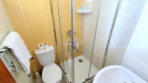 a bathroom with a toilet and a glass shower at Residencial Amarante in Mindelo
