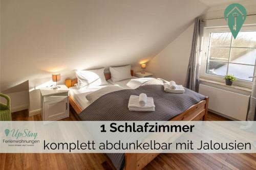 een slaapkamer met een bed met twee handdoeken erop bij Haus Hamburg OG in Greetsiel
