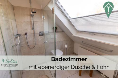 een badkamer met een douche en een glazen douchecabine bij Haus Hamburg OG in Greetsiel
