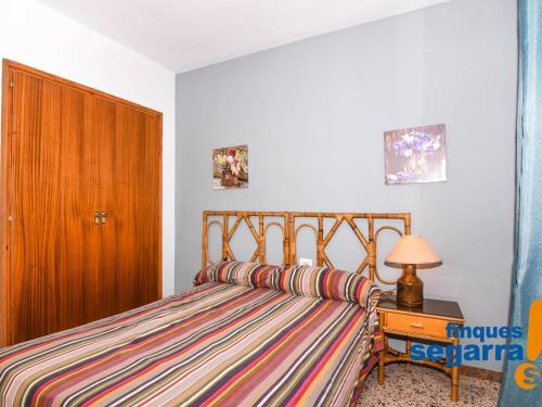 - une chambre avec un lit et une porte en bois dans l'établissement Apartamento Roda de Berà, 3 dormitorios, 6 personas - ES-320-2, à Roda de Bará