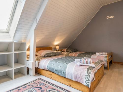 zwei Betten in einem Zimmer mit Dachboden in der Unterkunft Maison familiale avec piscine chauffée, proche plages et La Baule - FR-1-306-1266 in Saint-Molf