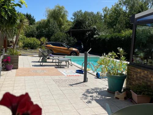 un patio avec une table et une piscine dans l'établissement Maison familiale avec piscine chauffée, proche plages et La Baule - FR-1-306-1266, à Saint-Molf