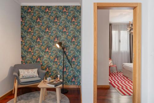 a living room with a wall with a floral wallpaper at Casa da Quinta Grande by An Island Apart in Câmara de Lobos