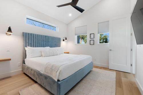 a bedroom with a large bed and two windows at Sunset Cove - Heated Pool - Sea Views - Walkable in Saint Augustine