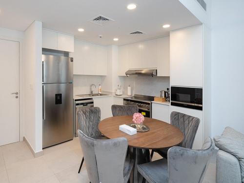 a kitchen with a table and chairs and a refrigerator at Brand new 2 Bedroom apartment in Madinat Jumeirah Living in Dubai