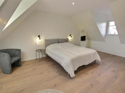 una camera bianca con un letto e una sedia di Maison Geispolsheim, 5 pièces, 8 personnes - FR-1-722-5 a Geispolsheim