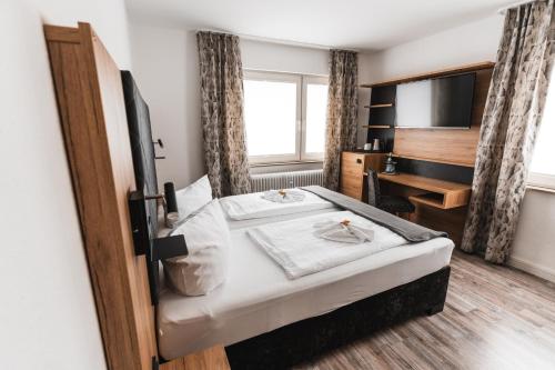 una camera d'albergo con letto e TV di Hotel Apartments Restaurant CALA LUNA a Marburg an der Lahn