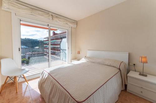 トッサ・デ・マールにあるApartamento Pau Picasso con terraza Tossa de Marのベッドルーム1室(ベッド1台、大きな窓付)