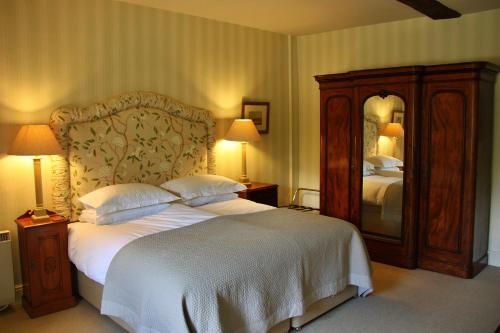 a bedroom with a large bed and a large mirror at Finest Retreats - Ingleby Manor - Gun Room in Great Ayton