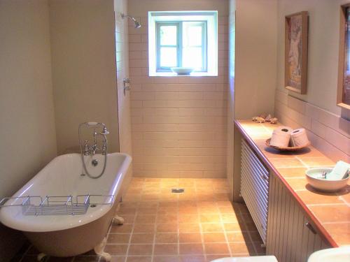 a bathroom with a bath tub and a window at Finest Retreats - Ingleby Manor - Gun Room in Great Ayton