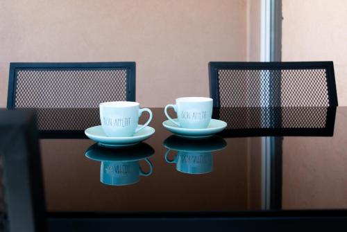 zwei Tassen und Untertassen auf einem Tisch in der Unterkunft Apartments Viki in Kruševo