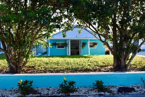 a blue house with two trees in front of it at Pinecraft Tiny Home 'Green Parrot ' in Sarasota