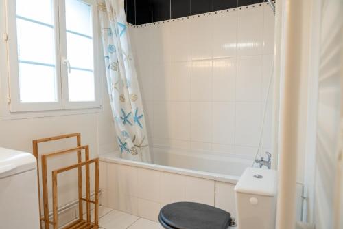 La salle de bains est pourvue d'une baignoire, de toilettes et d'un lavabo. dans l'établissement L'Avocette en Baie, à Saint-Valery-sur-Somme