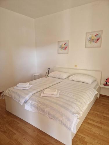 a white bed with two towels on top of it at Apartment Marta in Rab