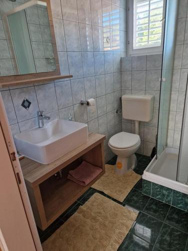 a bathroom with a sink and a toilet and a tub at Apartment Marta in Rab