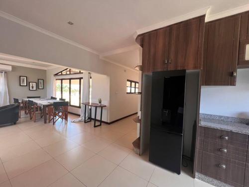 a living room with a kitchen and a dining room at Bantuz House in Livingstone