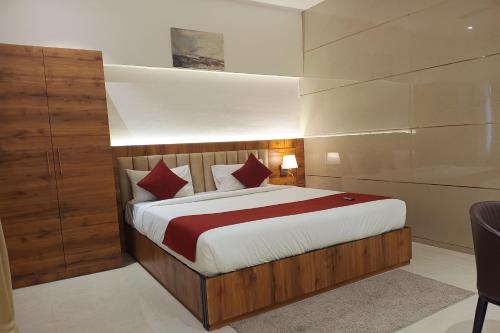 a bedroom with a large bed with red pillows at Madhav Residency Hotel & Banquet, Kalyan, Mumbai in Kalyan