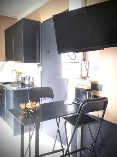 - une cuisine avec une table et deux chaises dans l'établissement Cosy & chic - Eiffel Tower, à Paris