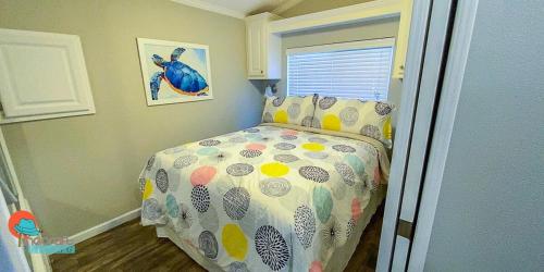 a bedroom with a bed with a comforter on it at Pinecraft Tiny Home 2 in Sarasota