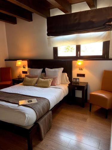 1 dormitorio con 1 cama grande y 1 silla en LA HOSTERIA DE TOLORIU, el alt Urgell, en Toloríu