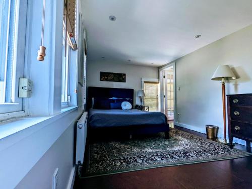 Un dormitorio con una cama azul y una ventana en Acadia Park Suites 2, en Southwest Harbor