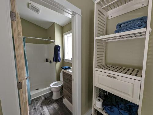 a bathroom with a shower and a toilet and a sink at Captains Quarters by the Beach in Ellsworth