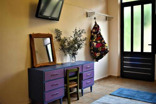 eine lila Kommode mit einem Spiegel und einem Spiegel in der Unterkunft Egaleo Relax Apartment in Athen