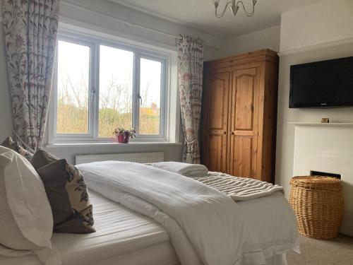 a bedroom with a bed with a television and a window at ABI B&B in Kent