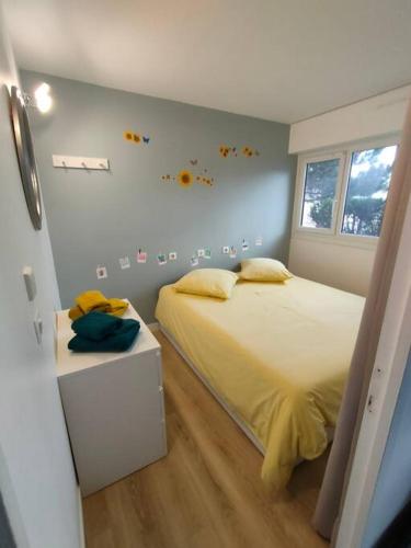 een slaapkamer met een groot bed en een raam bij Appt RdC terrasse, 300m plage. in Courseulles-sur-Mer