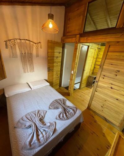 a bedroom with a large bed in a cabin at Pousada Reserva Setiba Guarapari in Guarapari