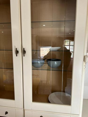a glass cabinet with a reflection of a table at Antic Cottage for Family in Nottingham