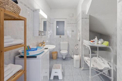 bagno bianco con lavandino e servizi igienici di Cà da Sott a Verscio