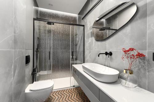 ein Bad mit einem WC, einem Waschbecken und einer Dusche in der Unterkunft Margi Dali Apartament PRESTIGE LUX HANZA TOWER in Stettin