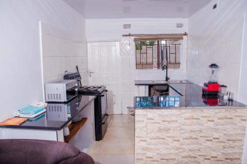 a small kitchen with a counter and a sink at Avery's Perch in Livingstone