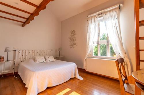 une chambre avec un lit et une grande fenêtre dans l'établissement Gite les oiseaux_A Louvemont avec piscine chauffée, à Louvemont