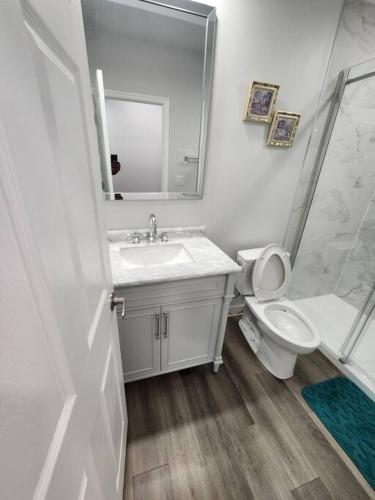 a bathroom with a sink and a toilet and a shower at Cozy one bedroom in Airdrie in Airdrie