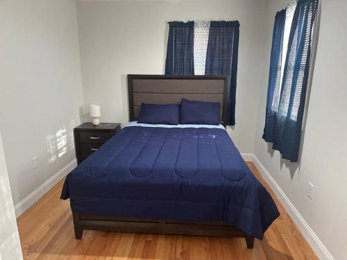a bedroom with a bed with a blue comforter at Modern Luxury Home With Fireplace & Game-Room in Brockton