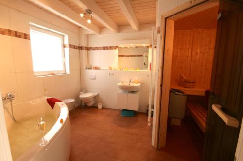 een badkamer met een bad, een toilet en een wastafel bij Auszeit - Nordhorn in Nordhorn