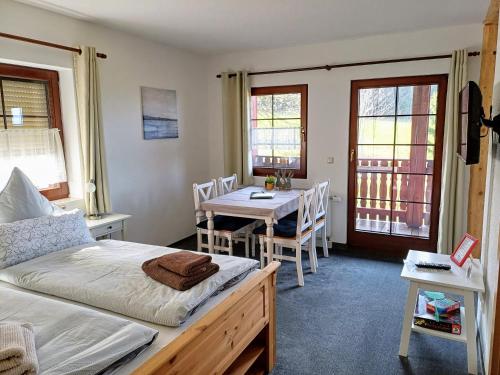 Schlafzimmer mit einem Bett, einem Tisch und Stühlen in der Unterkunft Ferienwohnungen 1 bis 4 "Pumphut's Scheune" in Lengenfeld