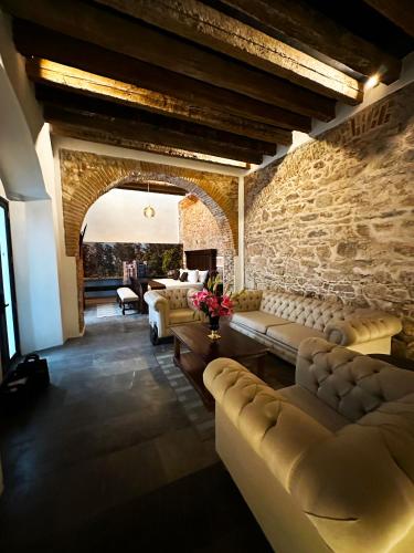 a living room with couches and a stone wall at HOTEL BOUTIQUE CASONA 65 in Puebla