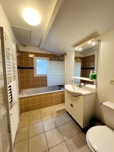 une salle de bain avec un lavabo, des toilettes et une baignoire dans l'établissement Bateau - Maison sous les pins, à Longeville-sur-Mer